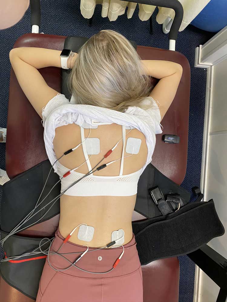 A Patient at Chiropractic Clinic, in Hurst Texas called Texas Back Care, is receiving Electric Muscle Stimulation during a treatment with Dr Carl Naehritz, Chiropractor